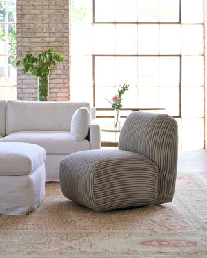  Striped chair next to a white sofa. Photographed in Hickory Noire. 