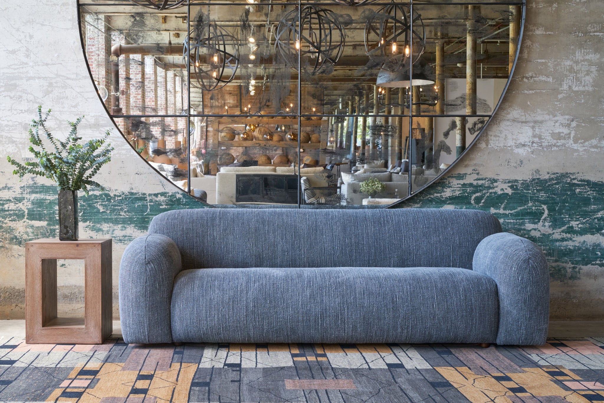  Grey sofa in front of a large mirror. Photographed in Bruges Indigo. 