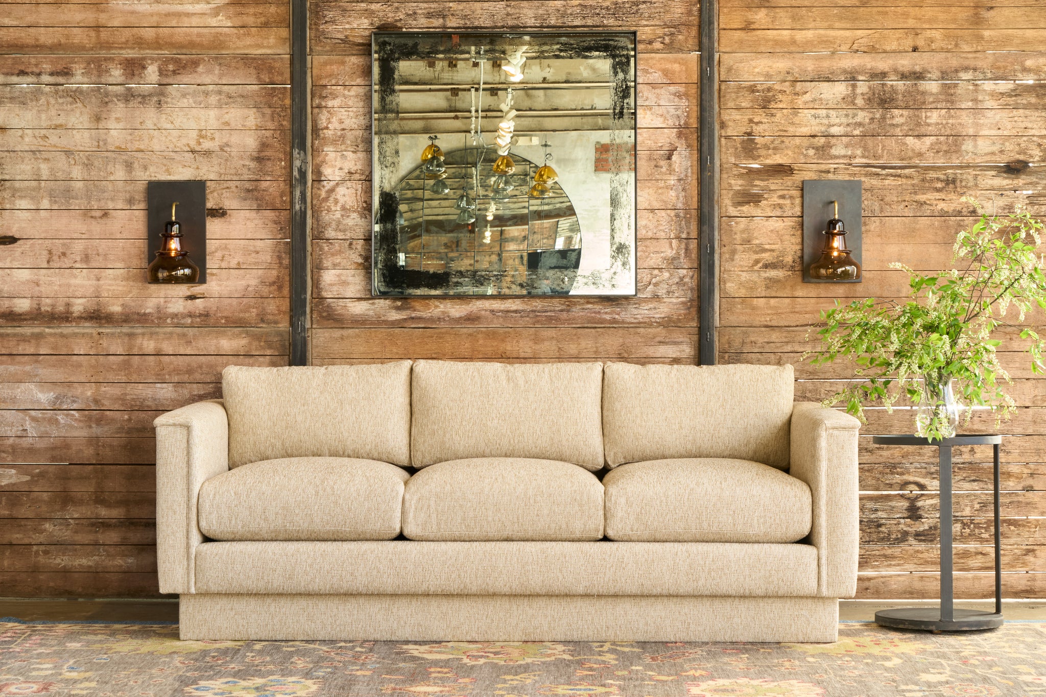  Oatmeal sofa in front of a wood wall with a mirror and sconces. Photographed in Ferrara Oatmeal. 