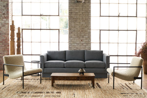  Blue sofa in a showroom with a chair on each side. Photographed in Knobby Mineral. 