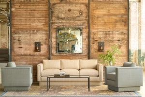  Chair in green linen in front of a wood wall.  Glass wall sconce and square mirror. Photographed in Ferrara Oatmeal. 