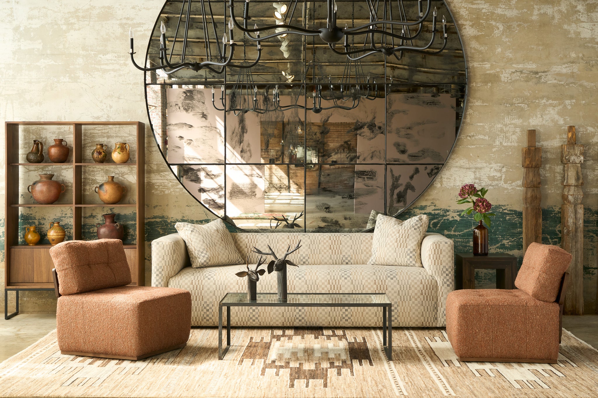  Modern living room with a round mirror, sofa, and armchairs. Photographed in Damas Mineral. 