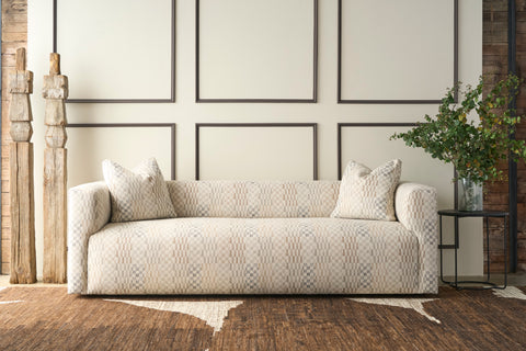 Patterned sofa in front of a white wall with grey molding. Photographed in Damas Mineral.