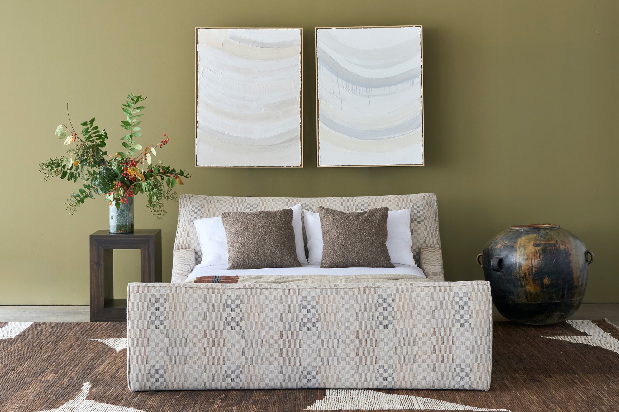  Living room with a patterned bed, decorative pillows, and wall art. Photographed in Damas Mineral. 