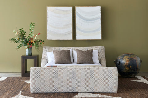 Living room with a patterned bed, decorative pillows, and wall art. Photographed in Damas Mineral.
