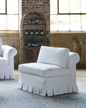  White chair with box pleat by a sofa. Photographed in Luna White. 