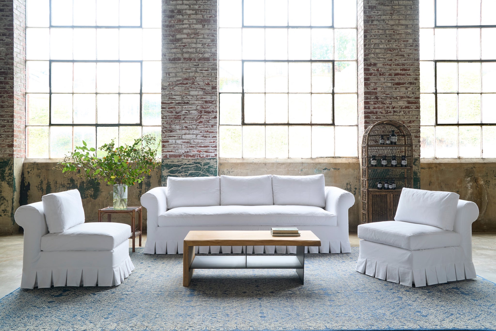  White sofa and chairs with a wood coffee table. Photographed in Luna White. 