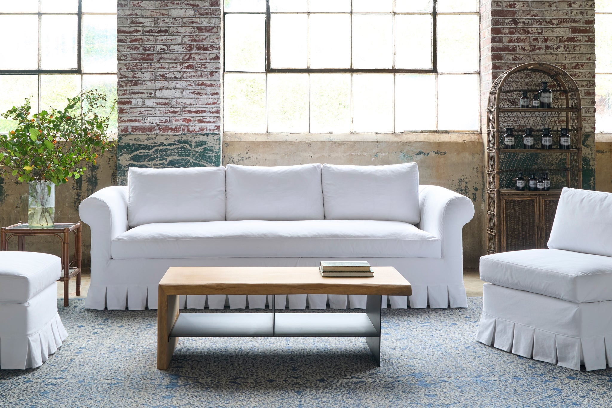  White sofa and chairs with a wood coffee table. Photographed in Luna White. 