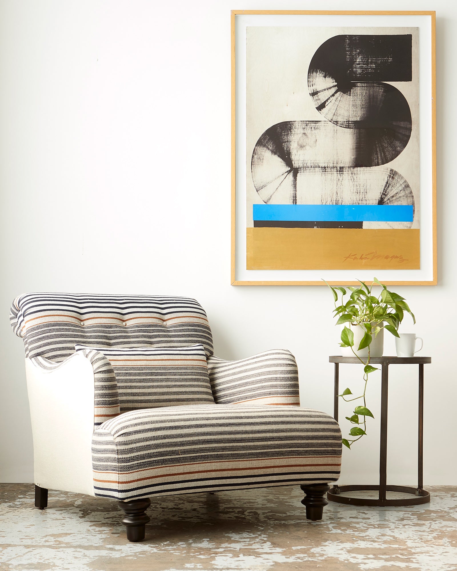  Acacia chair in Rayas Fino next to a round side table and art on the wall. Photographed in Rayas Fino. 