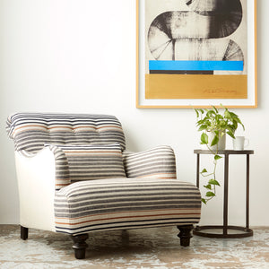  Acacia chair in striped fabric next to a round side table. Art on the wall behind. Photographed in Rayas Fino. 