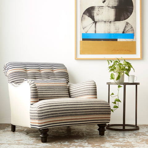 Acacia chair in Rayas Fino next to a round side table and art on the wall. Photographed in Rayas Fino.
