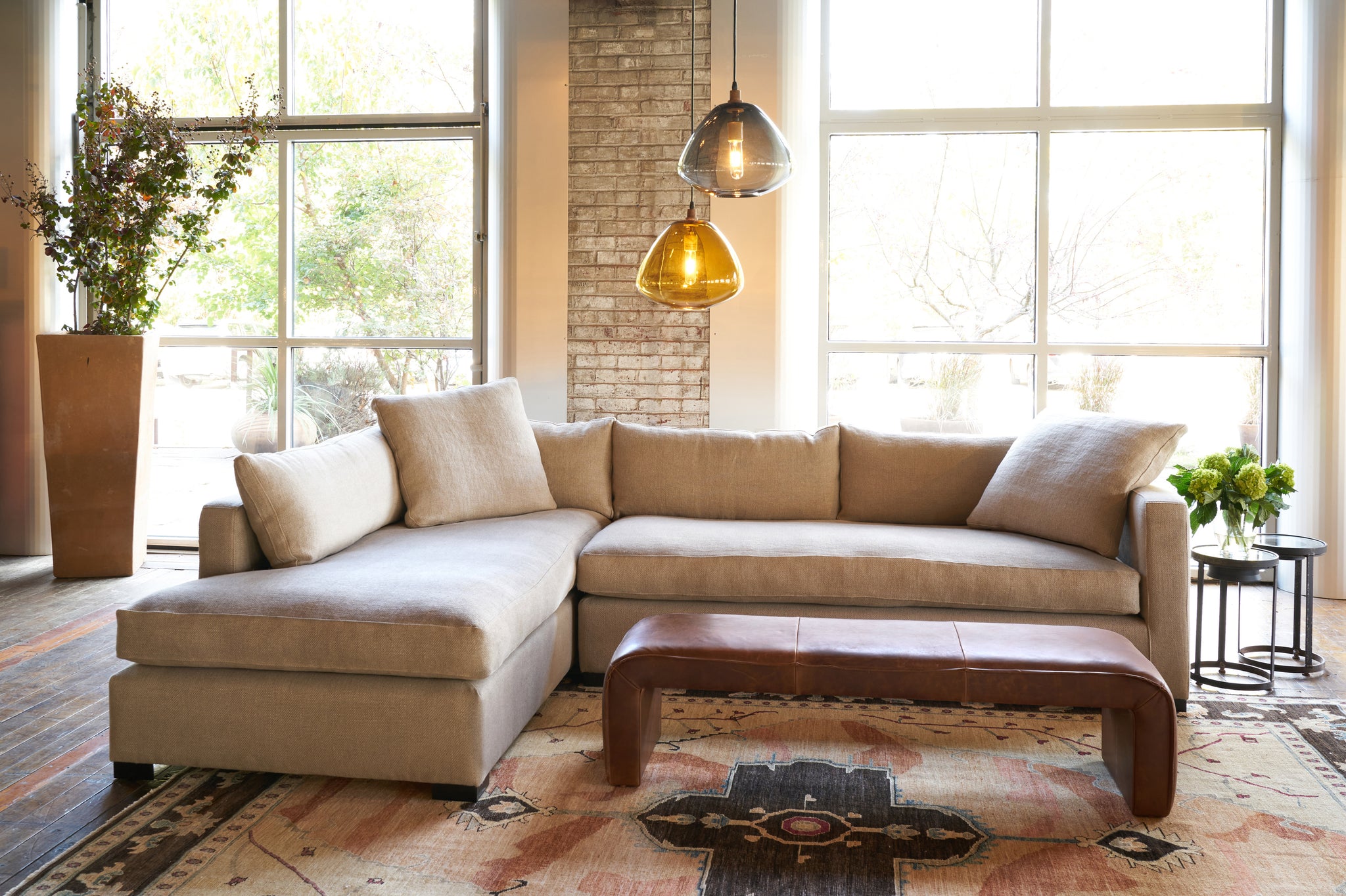  Sectional in front of large windows with 2 glass pendant and a leather bench. Photographed in Lan Oatmeal. 