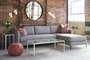  Sectional in front of a wood wall with a round mirror and white sconces. Red pouf on the left. Photographed in Carta Smoke. 