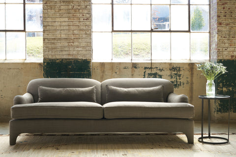 Sofa in front of large windows. Photographed in Rye Warm Grey.