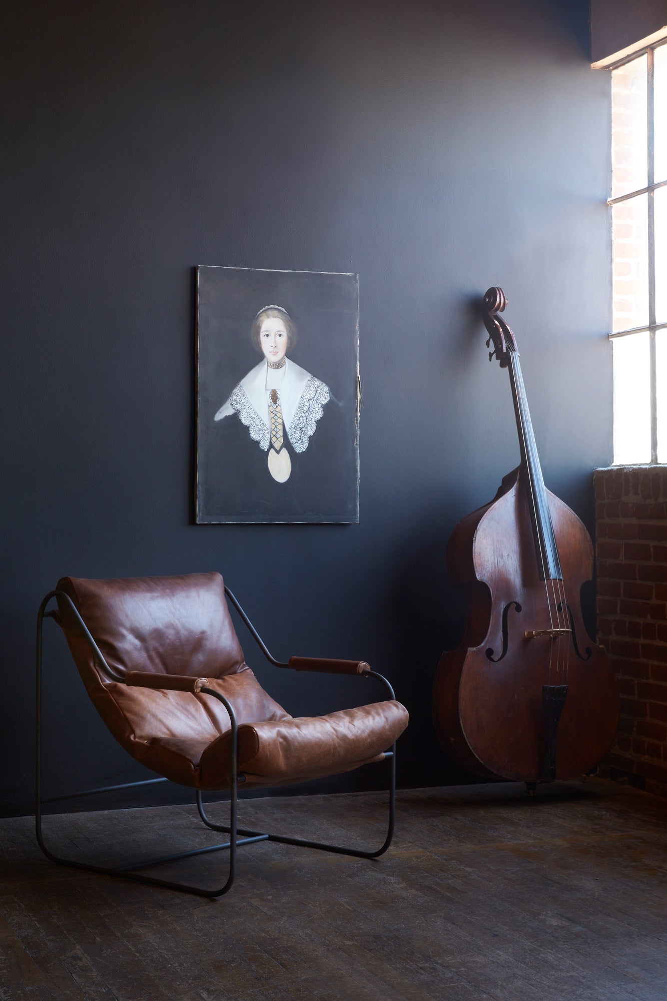  Chair in Spur Terracotta next to a violin. In the background is a dark room with a black painting hanging. Photographed in Spur Terracotta. 