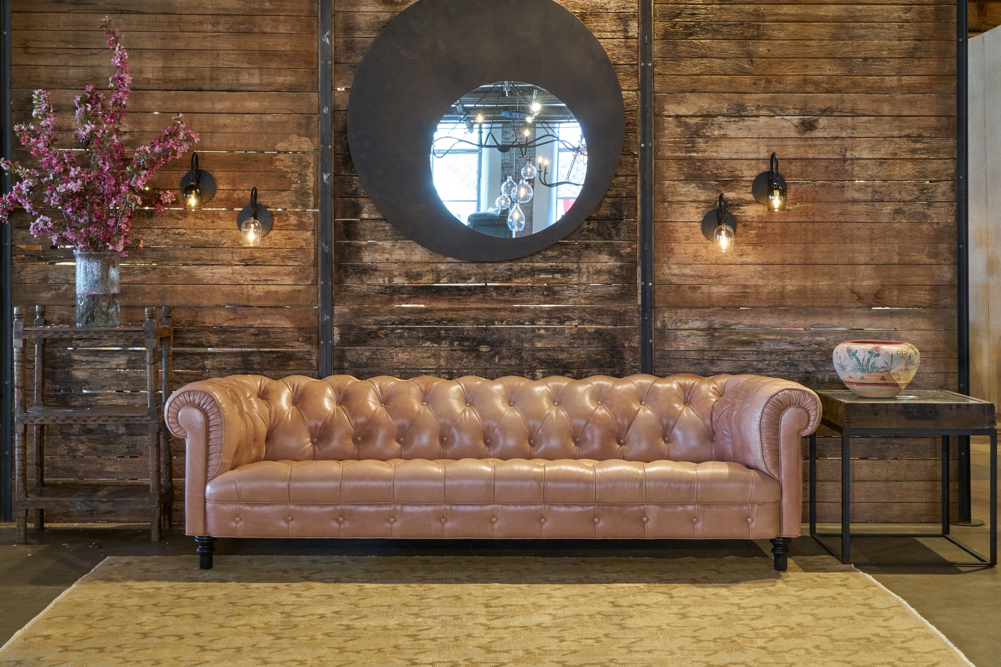  Pink leather tufted sofa in front of a wood wall. Photographed in Solvang Mauve 