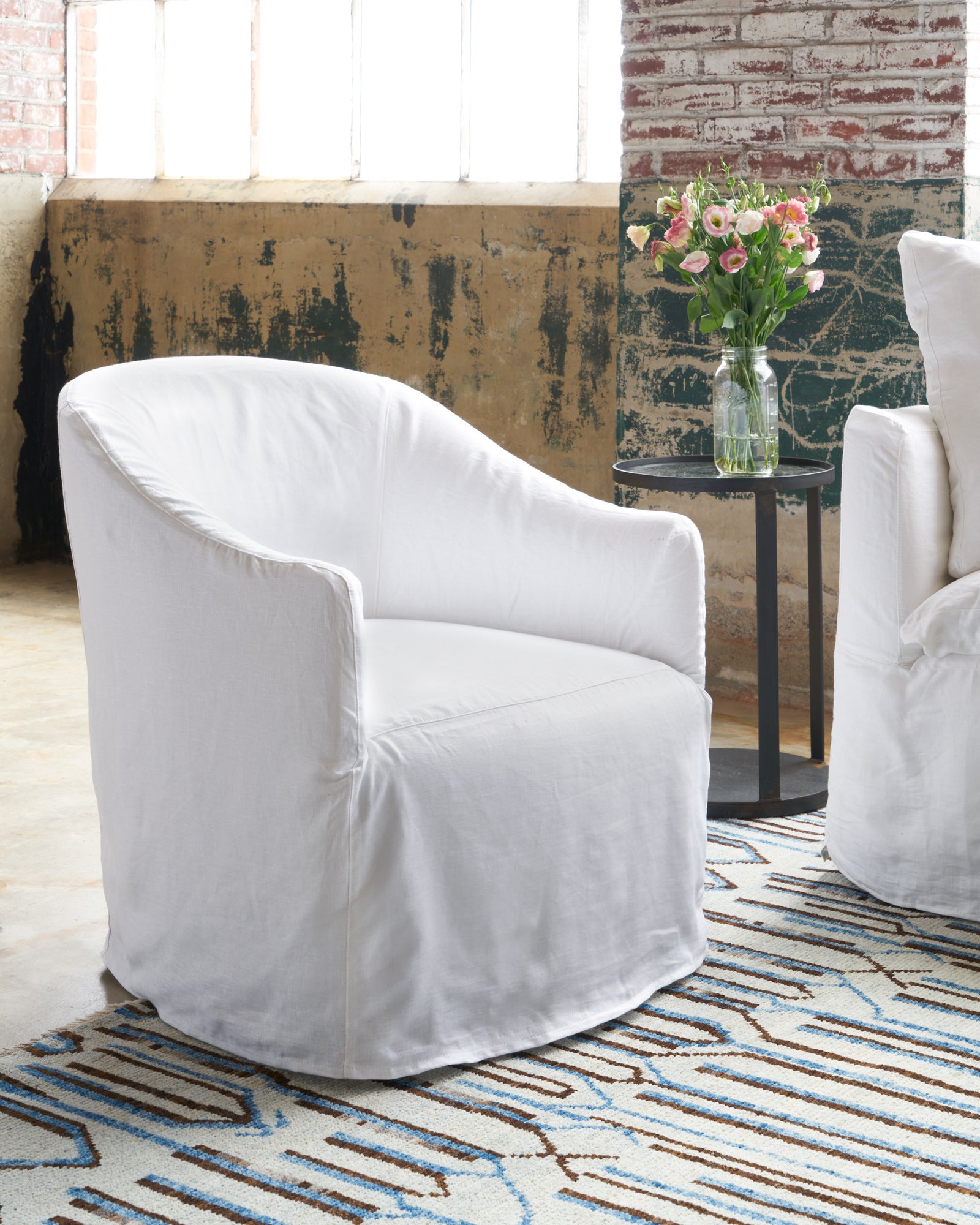  Cali Chair in Otis White next to a side table. Photographed in Otis White. 