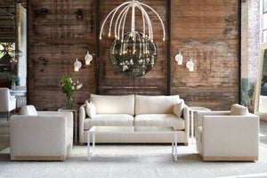  Loveseat with 2 chairs in front of a wood wall with a round mirror and with coffee table. 