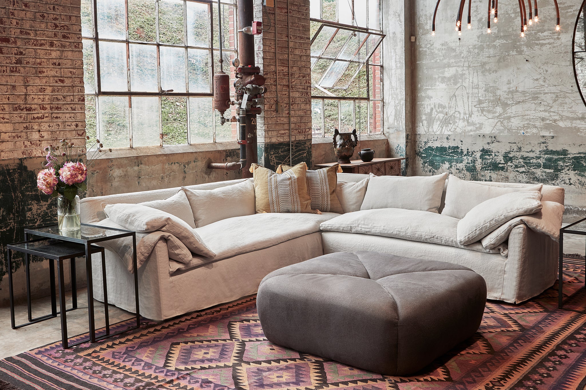  Tonto Ottoman Large in  Lan Espresso next to a grey sectional. Photographed in Lan Espresso. 