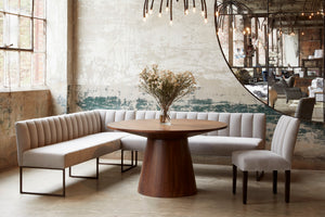  Light filled interior with round dining table flanked by two Enzo Banquettes in Pierre Stone and one dining chair. Photographed in Pierre Stone. 