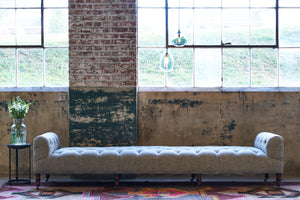  Field Bench 108" in Raven Peppercorn in front of a painted brick wall. Photographed in Raven Peppercorn. 