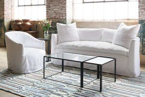  Cali Chair in Otis White next to a white sofa and coffee table. Photographed in Otis White. 