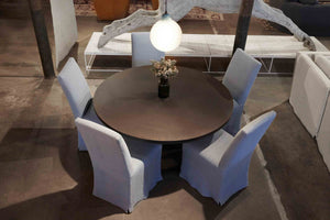  Round metal dining table with five slip covered dining chairs in light grey fabric and one large just pendant in ice finish hanging above dining table.  
