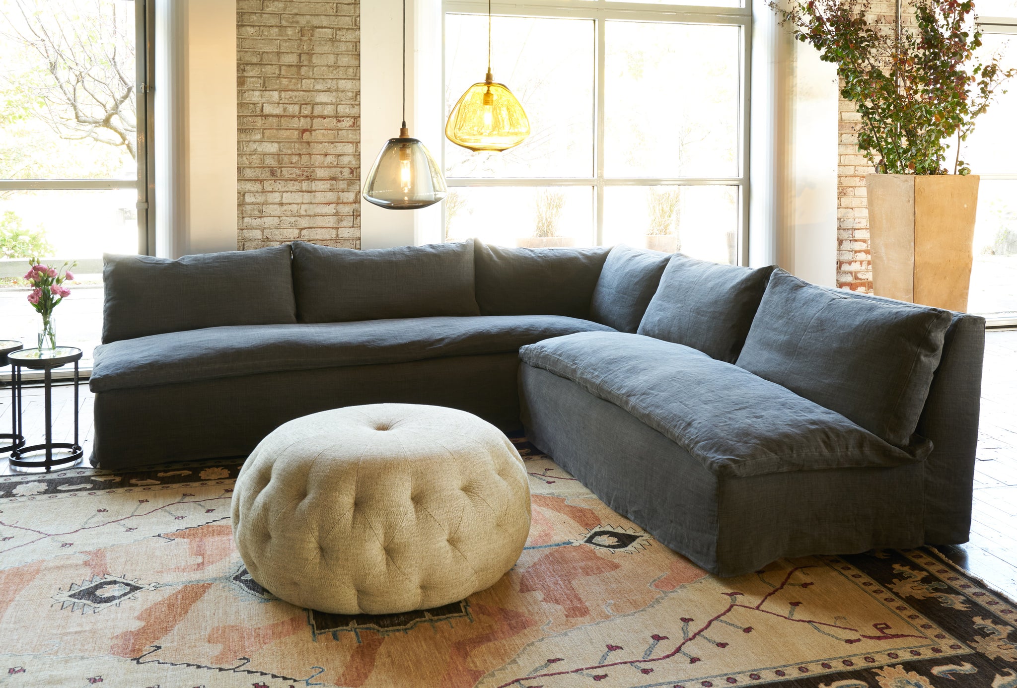  Black sectional with a pouf ottoman in front. Photographed in Rye Black. 