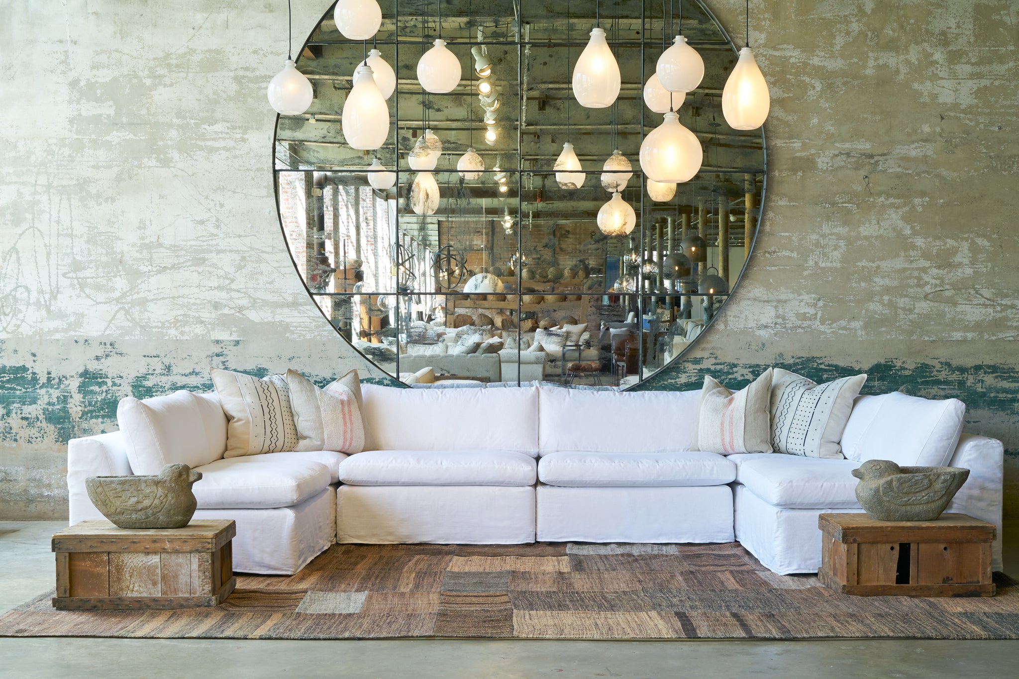  Six pieces slipcovered sectional in white in front of an oversized mirror. Photographed in Otis White 