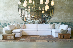  Six pieces slipcovered sectional in white in front of an oversized mirror. Photographed in Otis White 