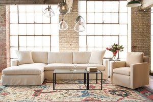  Louis Sectional in Lester Snow next to a glass coffee table with glass jug lamps hanging above. Photographed in Lester Snow. 
