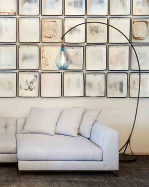  Upholstered sectional in light fabric with mantis floor lamp hanging over with jug oval lamp in sky finish.  