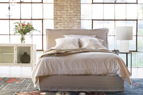 Paloma bed in Logan Mist next to a metal side table and a white credenza. Photographed in Logan Mist.