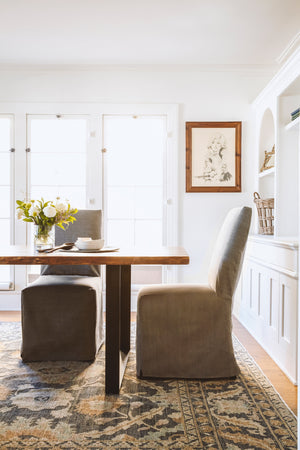  Parsons dining chair in Molino Ash next to a wood dining table. In the background is white room with a wood picture frame and glass doors. Photographed in Molino Ash. 