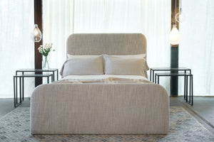  Bed facing in a room with white curtains behind. Two nesting side tables on each side. Photographed in Cameron Natural. 