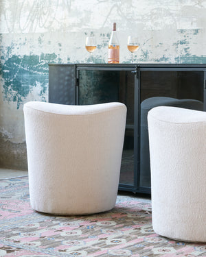  Two counter stools in white in front of a dark credenza. Photographed in Lumi Bone 