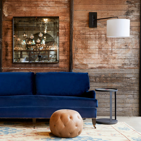Pouf Ottoman 20 in Marvell Chestnut next to a blue sofa. Photographed in Marvell Chestnut.
