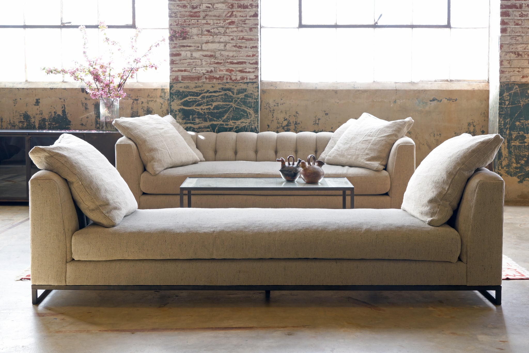  A daybed and a sofa in front of a wall with 2 large windows. Photographed in Andrews Burlap 