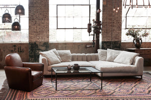  Sectional in a shworoom with a leather club chair on the left. Photographed in Brevard Burlap. 