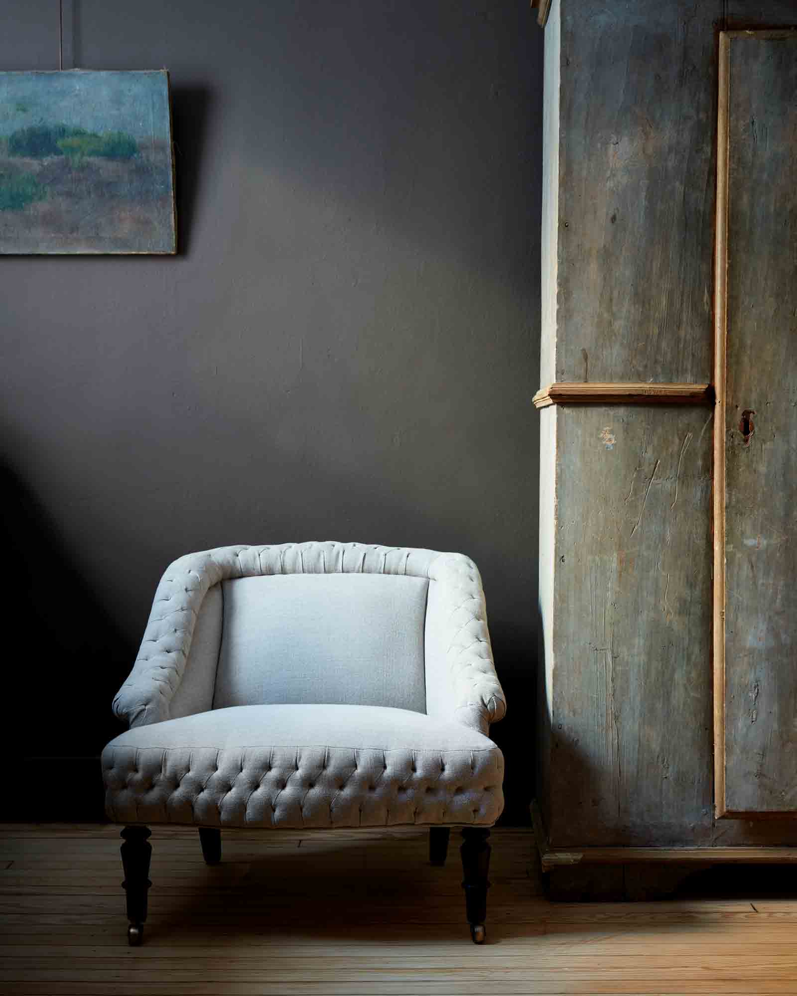  Royal chair in Vintage Flax. In the background are dark colored walls with a painting hanging. Photographed in Vintage Flax. 