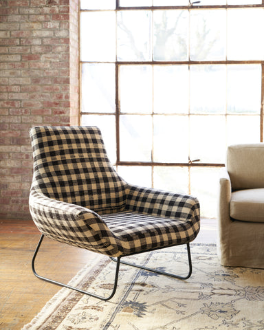 Checkered brown and white chair with a metal base in front of a large window. Photographed in Pisco Espresso.