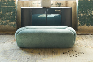  Bench in a showroom in front of a metal credenza. Photographed in Velluto Aqua. 