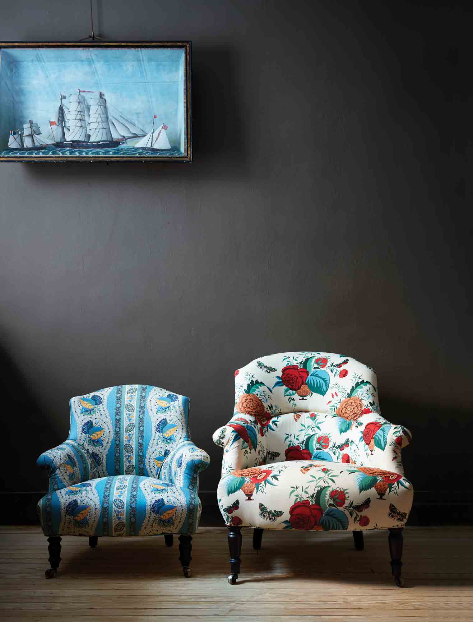  Tulip chair in John Derian Fabric next to a print chair. In the background is a dark wall with a ship in the water art piece. Photographed in John Derian fabric. 